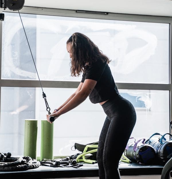 female personal trainer using cable machine